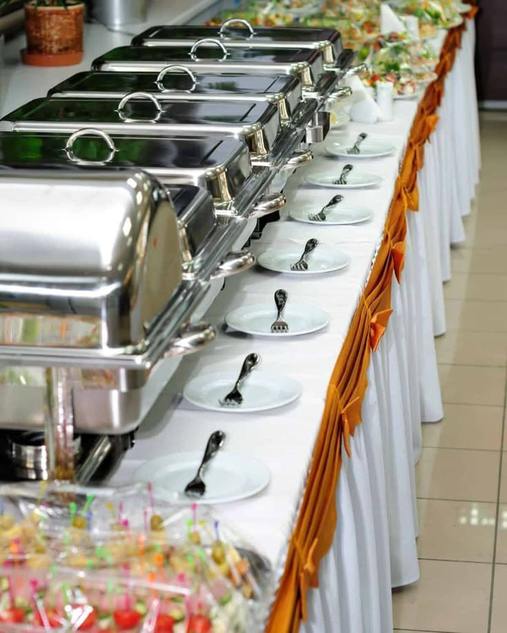 Signature Catering chefs setting up chafing dishes at an event in Islamabad